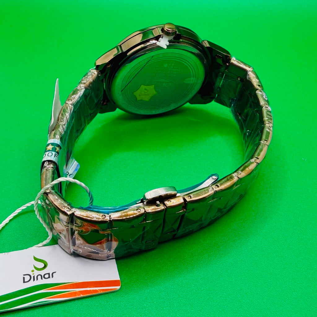 Metallic watch with a visible brand tag on a green background