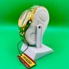 Gold and green watch on a white stand with a 'IRADD' tag against a green background