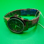 Green wristwatch with a metal band on a green background