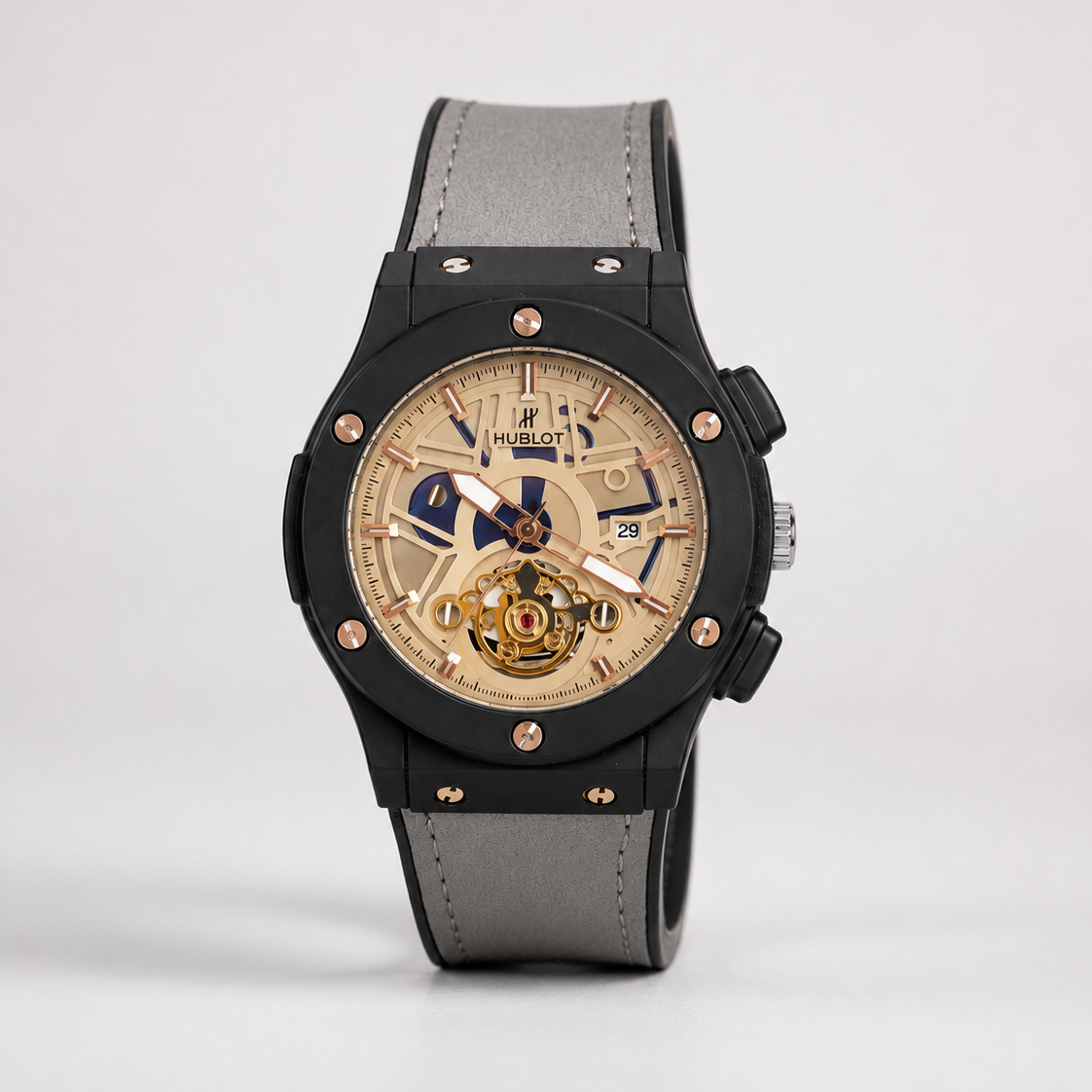 Luxury watch with black case, gray strap, and beige dial on a light gray background